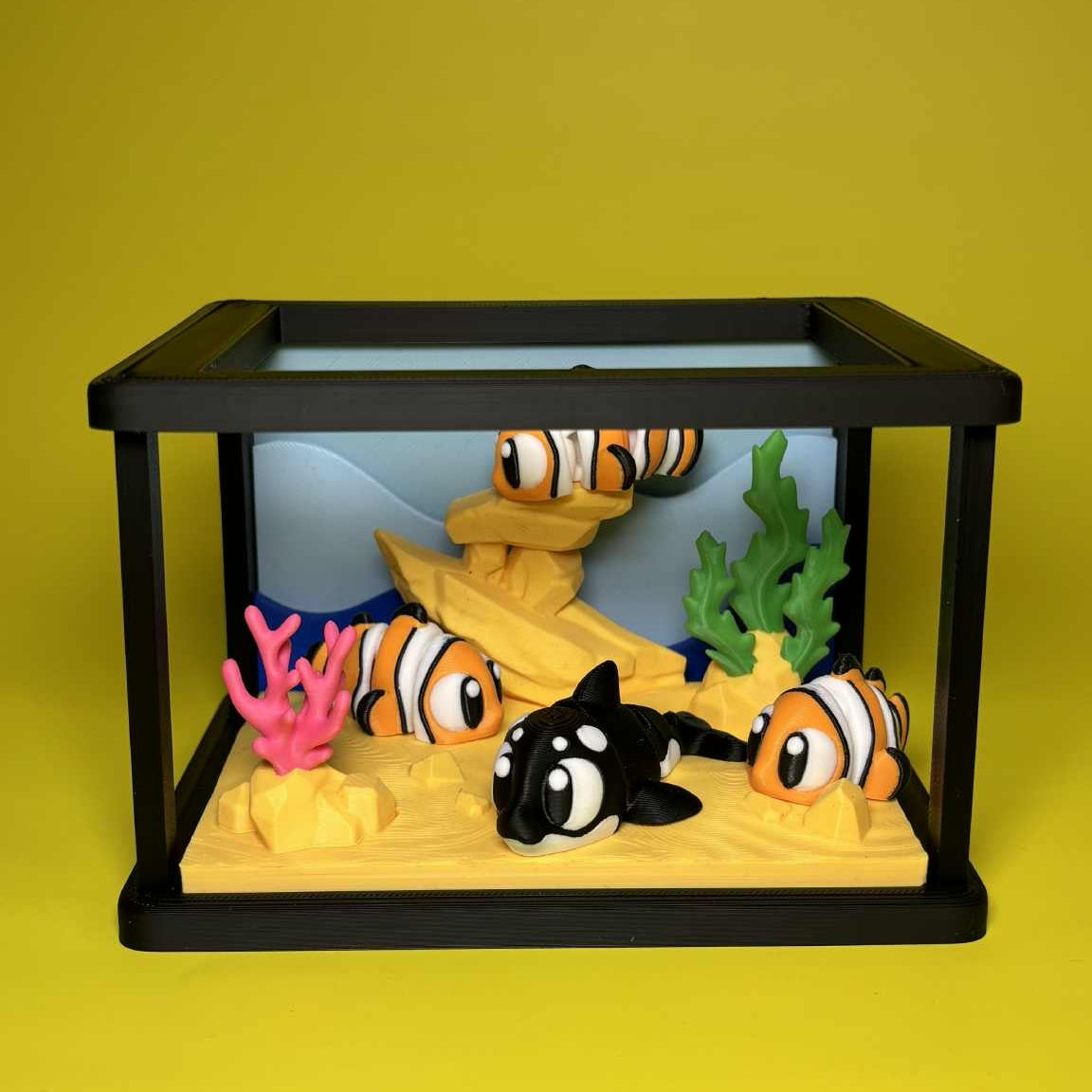 Model aquarium with fish and coral on a yellow background